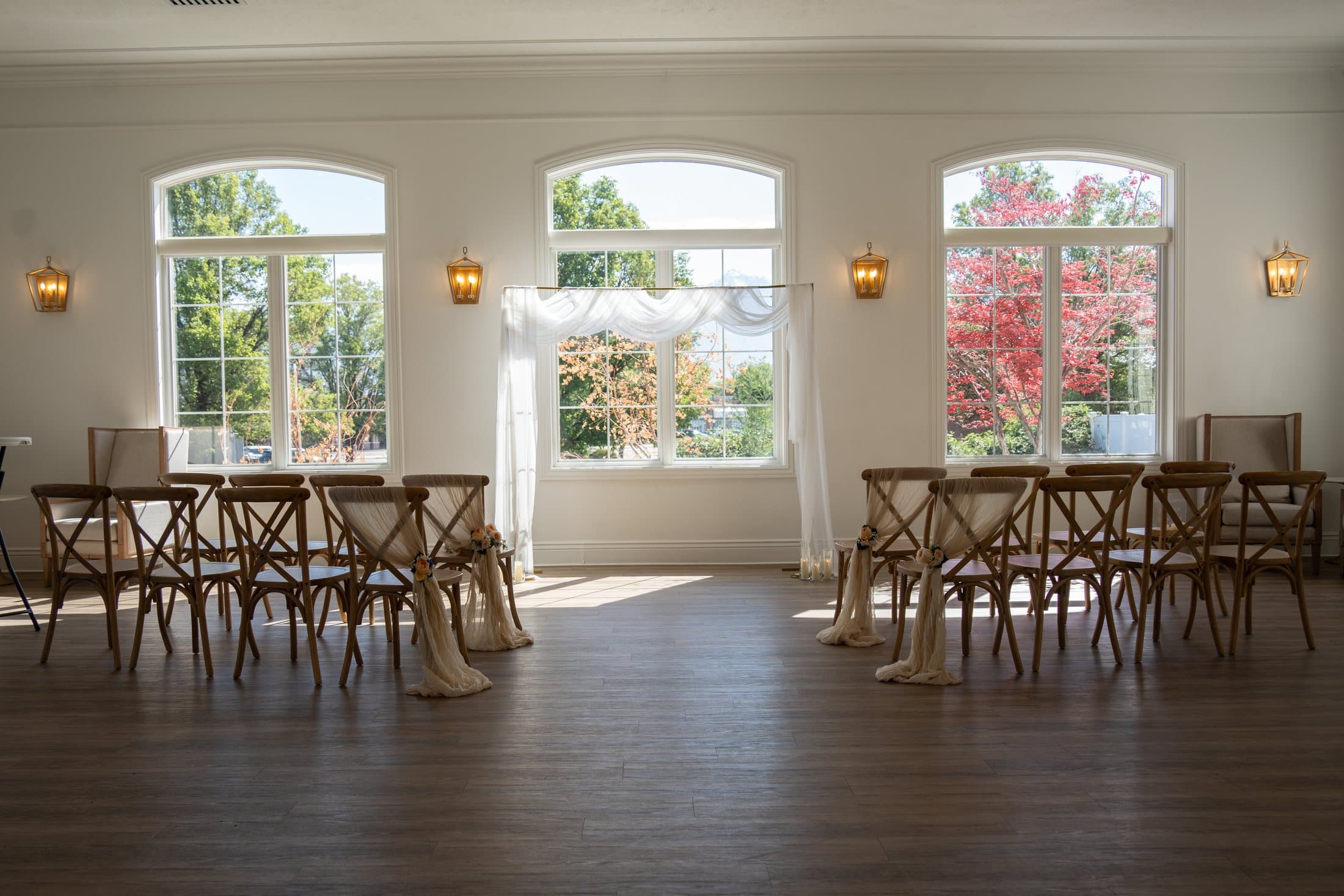 Sunlight filling the Magnolia styled photoshoot venue, with flowers, draped fabric, and rows of chairs